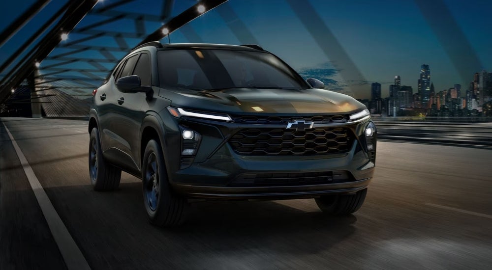 A black 2026 Chevy Trax Midnight Edition driving on a bridge