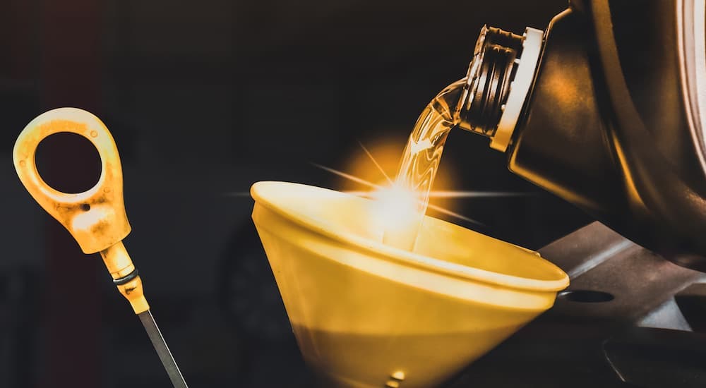 An oil can being poured into a funnel.