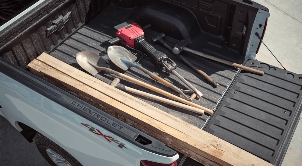 Tools in the bed of a white 2023 Chevy Silverado 1500 WT.