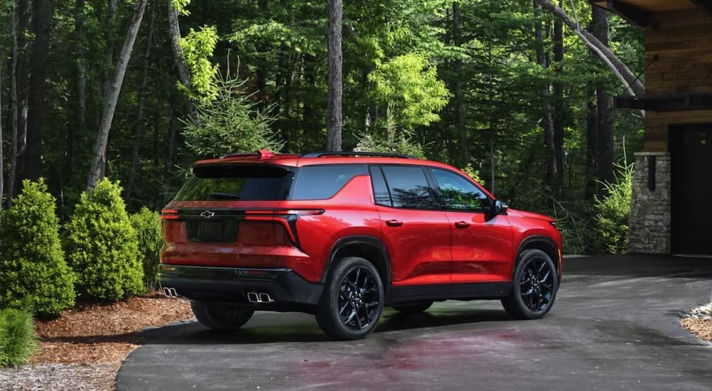 A red 2025 Chevy Traverse RS parked on a driveway.
