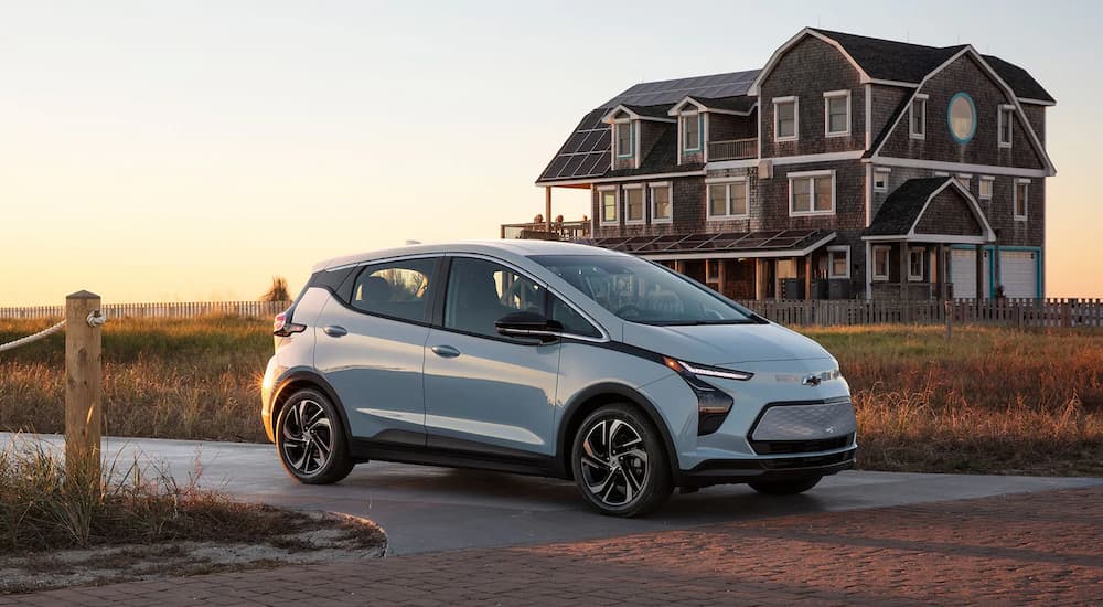 Light blue 2022 Chevy Bolt EV parked at the end of a driveway.