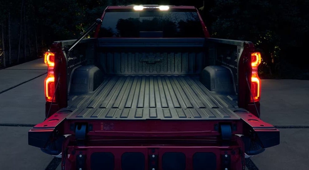 Rear view of a red 2024 Chevy Silverado 1500 with an open tailgate.