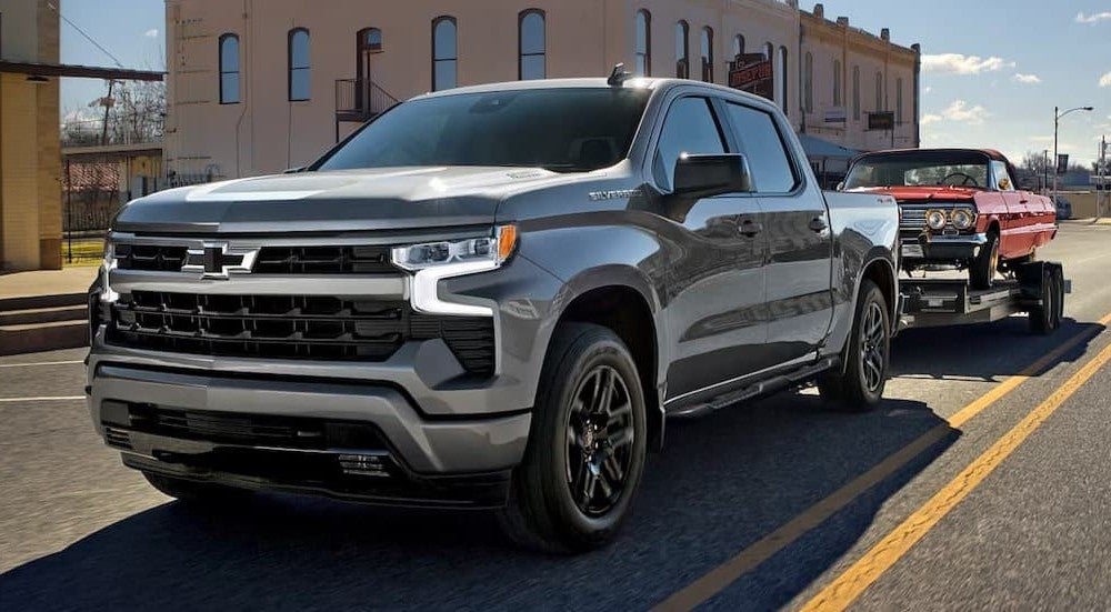 A silver 2026 Chevy Silverado 1500 towing a trailer.