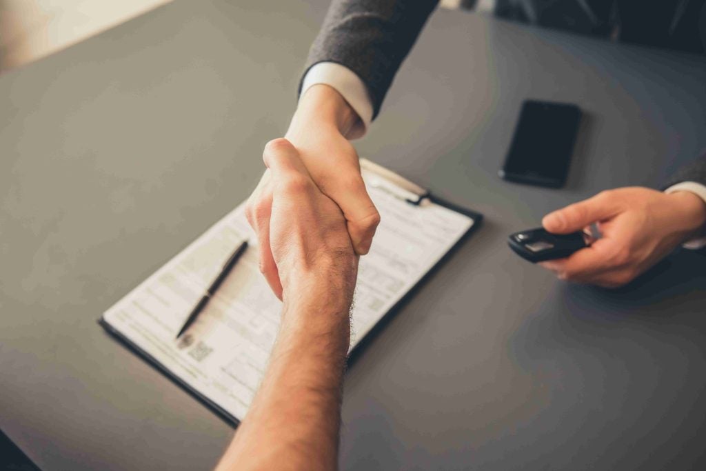 Hands shaking over a contract.