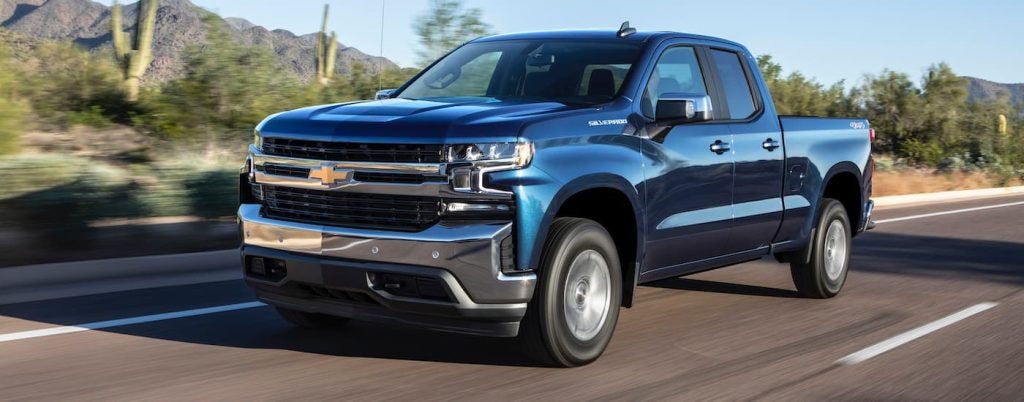 A blue Chevy Silverado 1500 driving in the countryside.