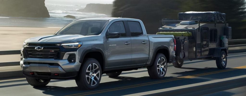 A grey 2023 Chevy Colorado Z71 towing a trailer.