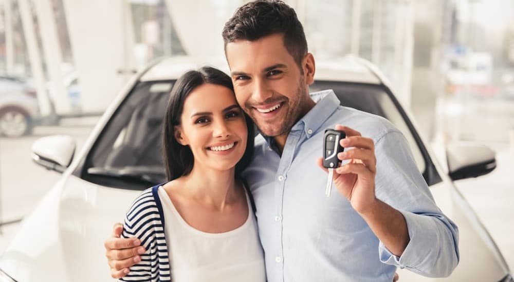People smiling and holding a key fob.
