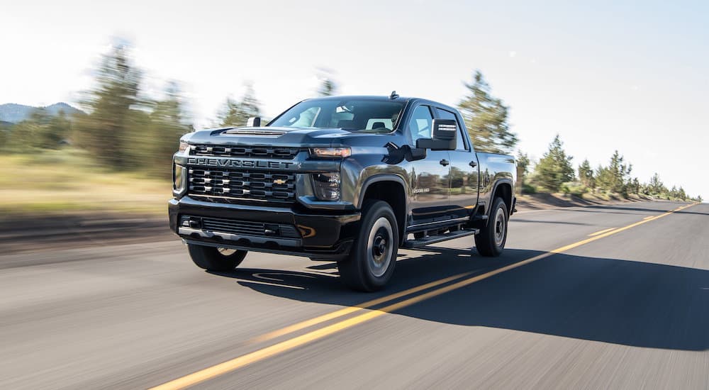 A black 2020 Chevy Silverado 2500 HD driving on a highway.
