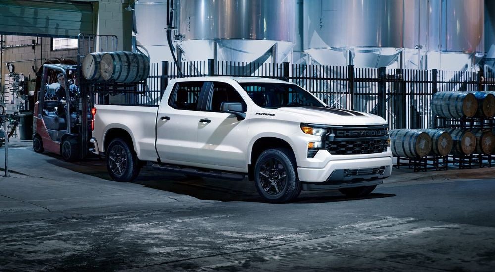 A white 2024 Chevy Silverado 1500 Rally Edition being loaded with barrels.