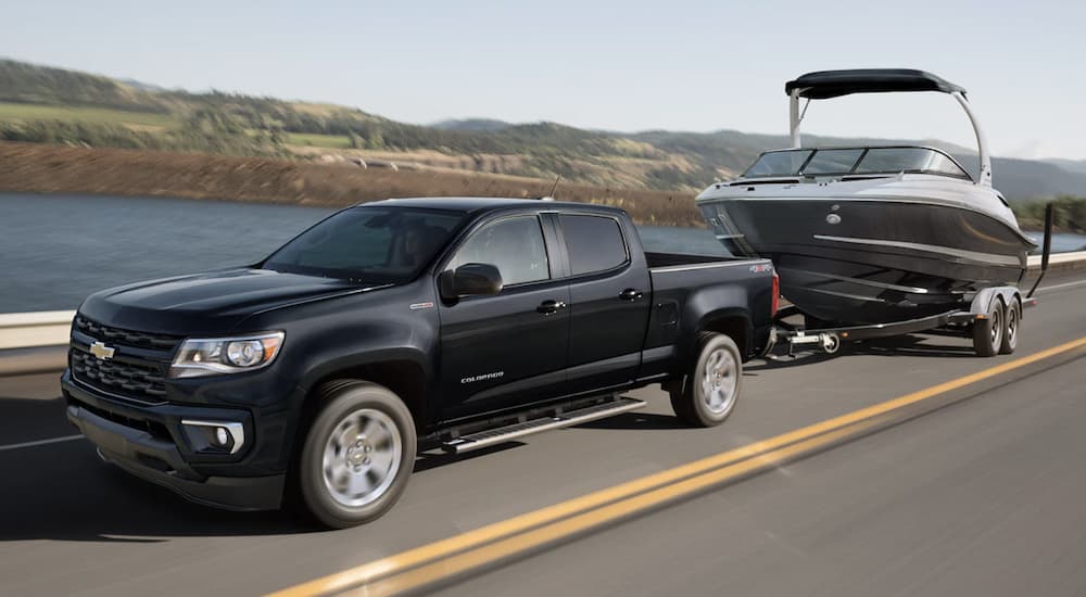 A black 2022 Chevy Colorado towing a boat.
