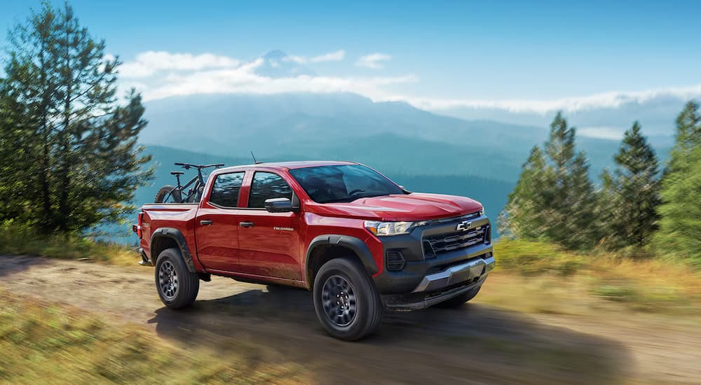 A red 2025 Chevy Colorado off-roading on a dirt trail