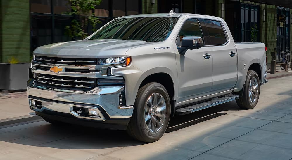 A silver 2021 Chevy Silverado 1500 is driving to a San Antonio Chevrolet dealer.