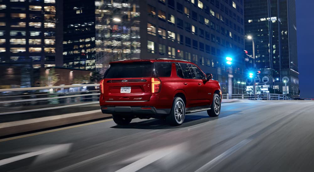 Red 2022 Chevy Tahoe driving on a highway at night.