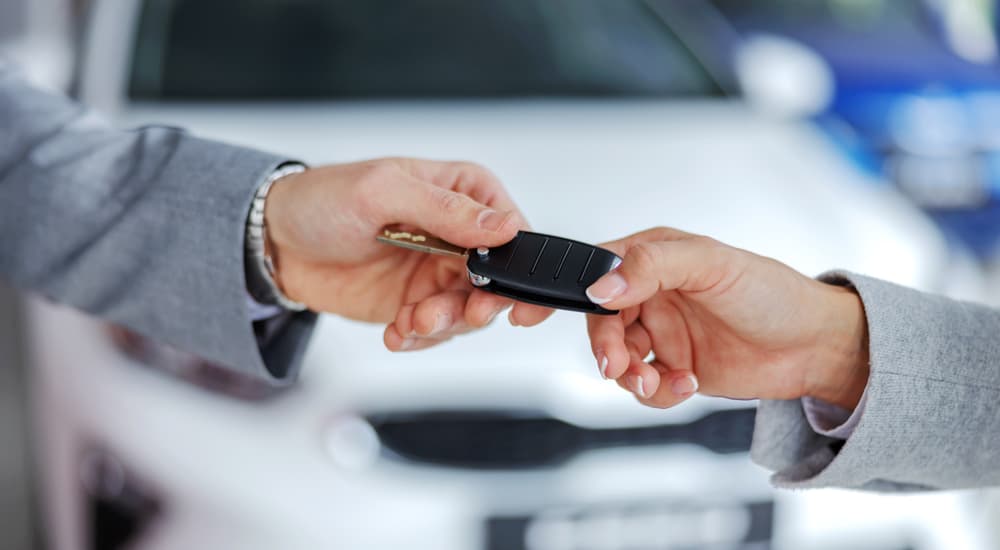 Salesman taking a key from a customer that sold their car.