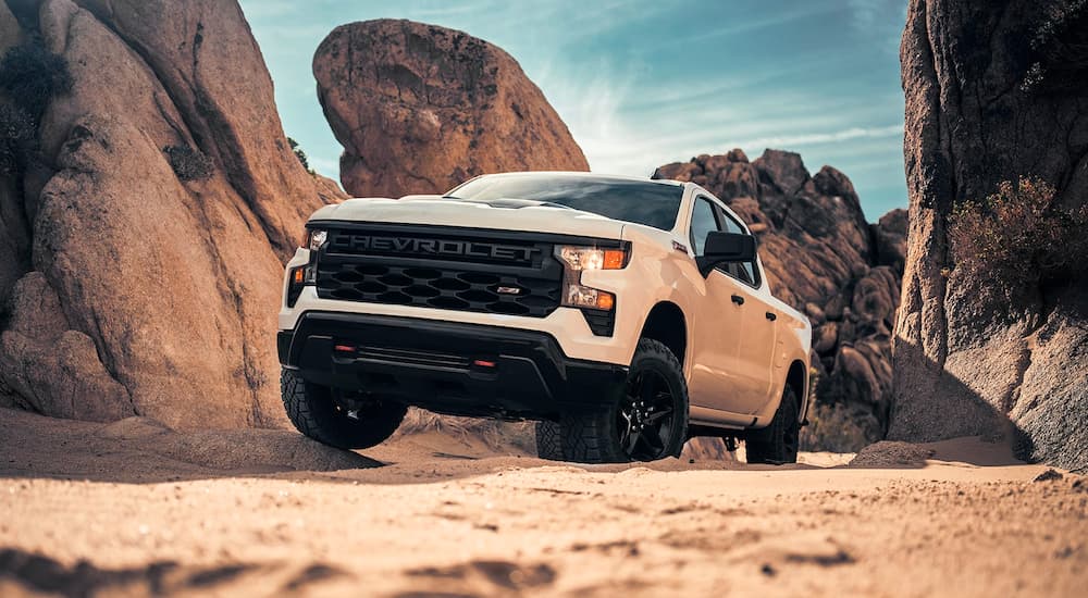 White 2024 Chevy Silverado 1500 Custom driving on rocks.