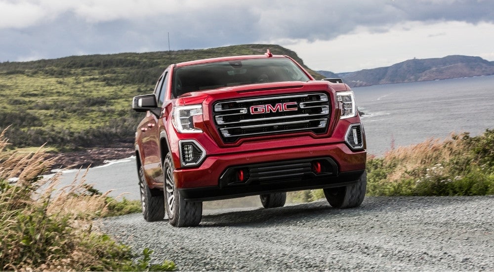 A red 2019 GMC Sierra 1500 AT4 driving on a gravel trail.