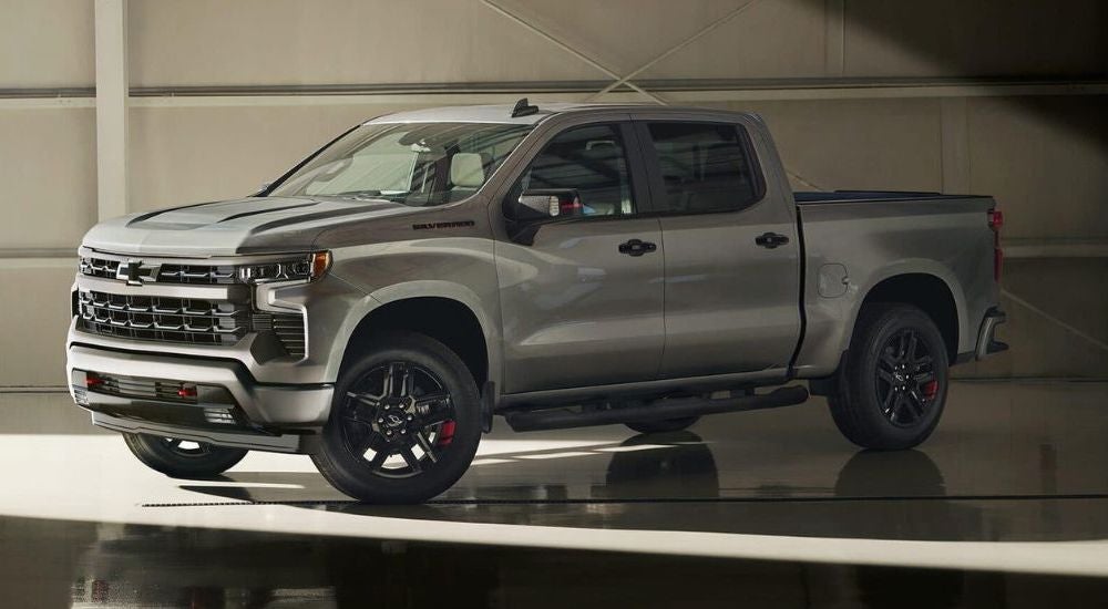 A grey 2024 Chevy Silverado 1500 Redline parked in a showroom.
