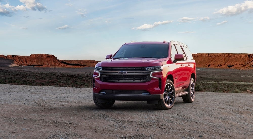 A red 2022 Chevy Tahoe RST is parked on a dirt lot.