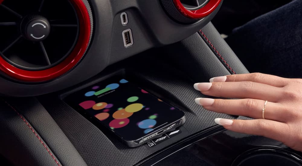 Hand reaching for a phone in a 2025 Chevy Blazer.