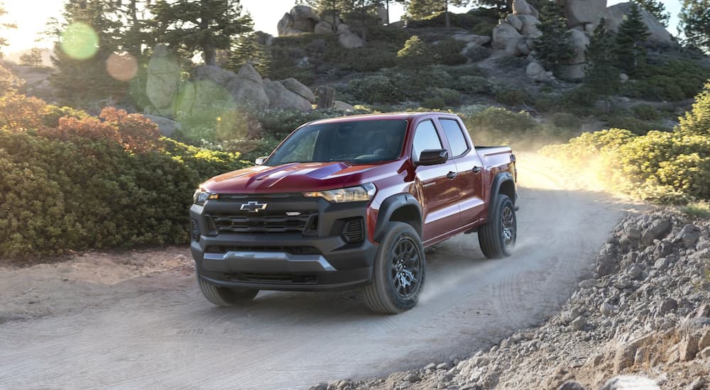 A red 2023 Chevy Colorado Trail Boss driving down a dirt road.