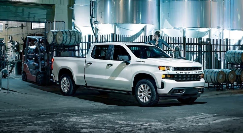 A white 2022 Chevy Silverado 1500 LTD is being loaded with barrels.