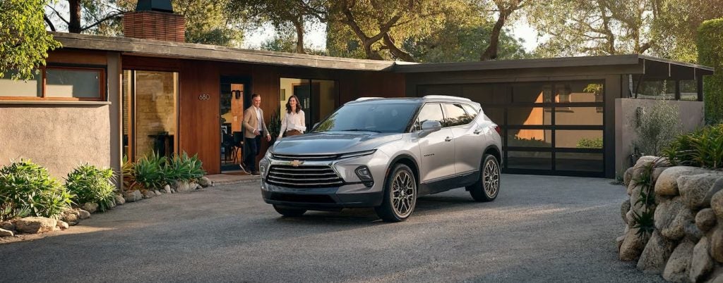 A silver 2024 Chevy Blazer parked outside of a home.