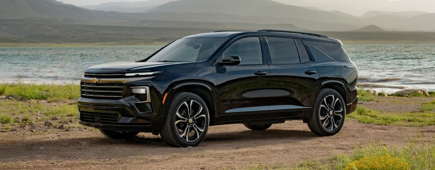 A black 2027 Chevy Traverse parked near water.