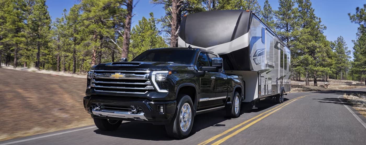 A black 2026 Chevy Silverado 2500 towing a trailer.