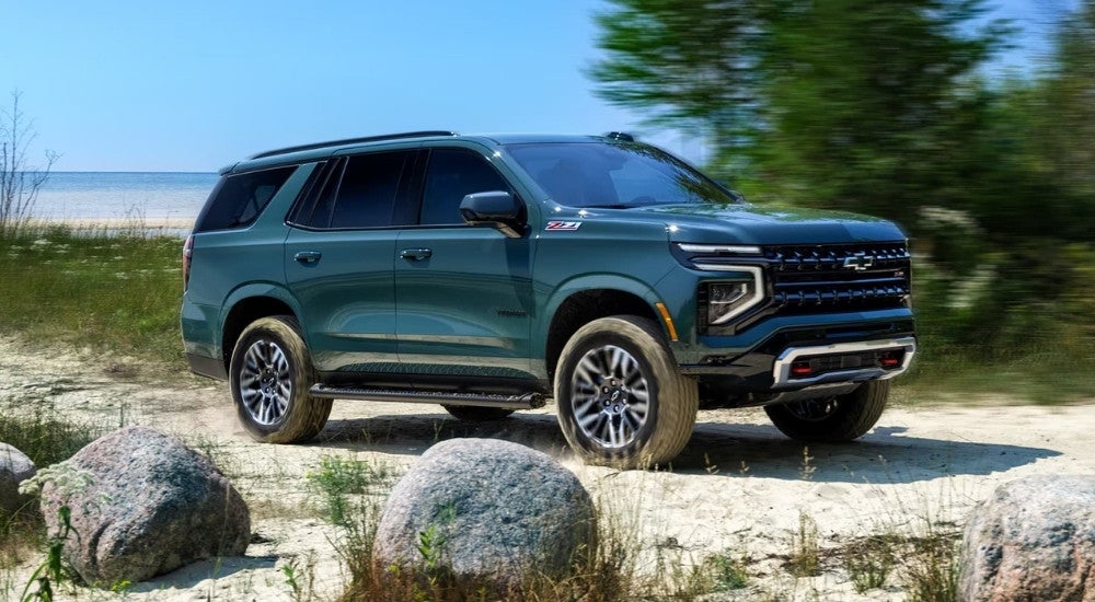 A green 2025 Chevy Tahoe Z71 driving on a trail.