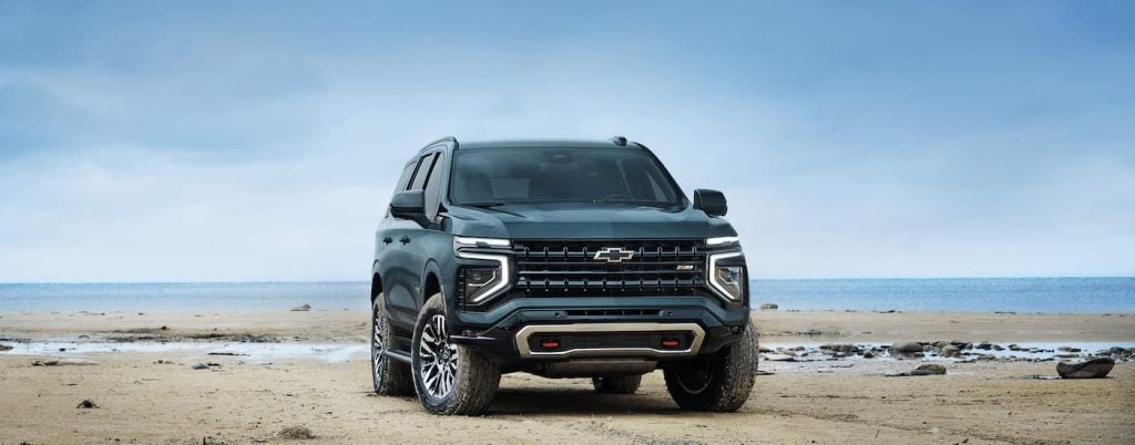 A green 2025 Chevy Tahoe Z71 driving on a beach.