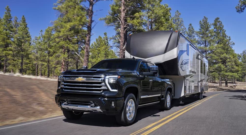 A black 2026 Chevy Silverado 2500 towing a trailer.
