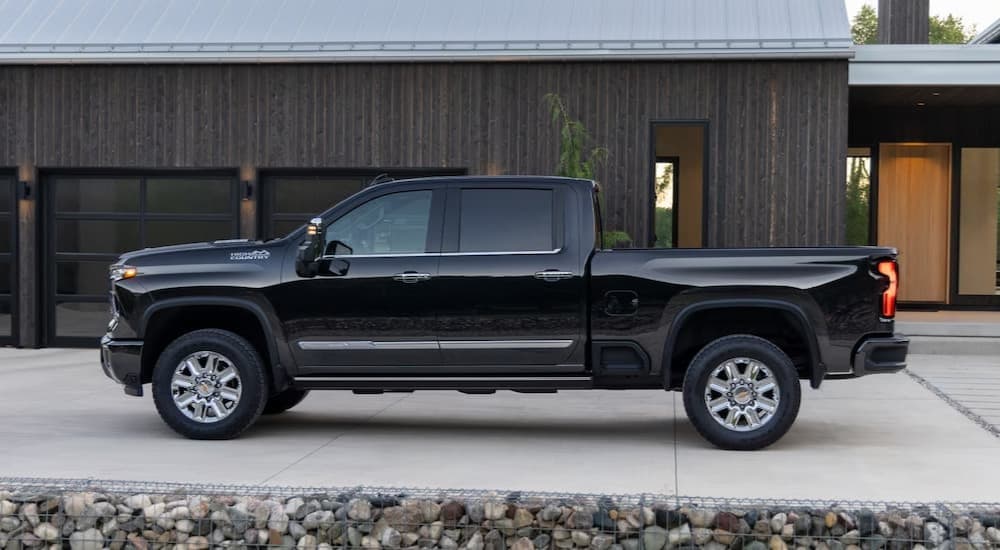 A black 2025 Chevy Silverado 2500 HD parked on a driveway.