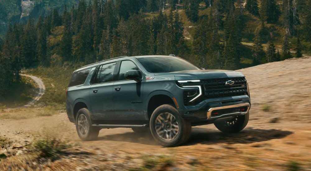 Green 2026 Chevy Suburban Z71 off road on a trail.