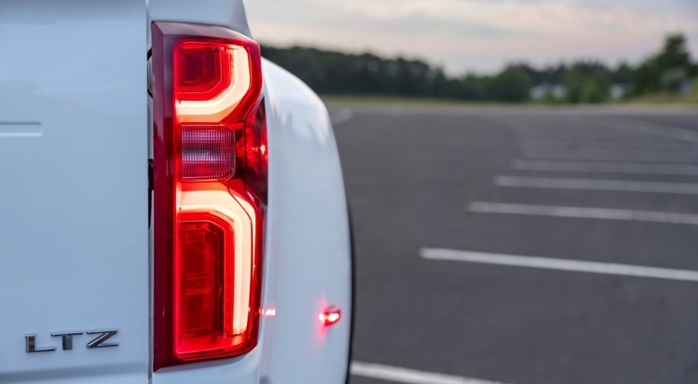 Illuminated passenger side taillight on a white 2025 Chevy Silverado 3500 HD LTZ.