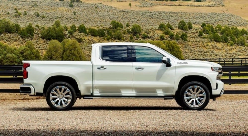 A white 2025 Chevy Silverado 1500 High Country parked on a ranch.