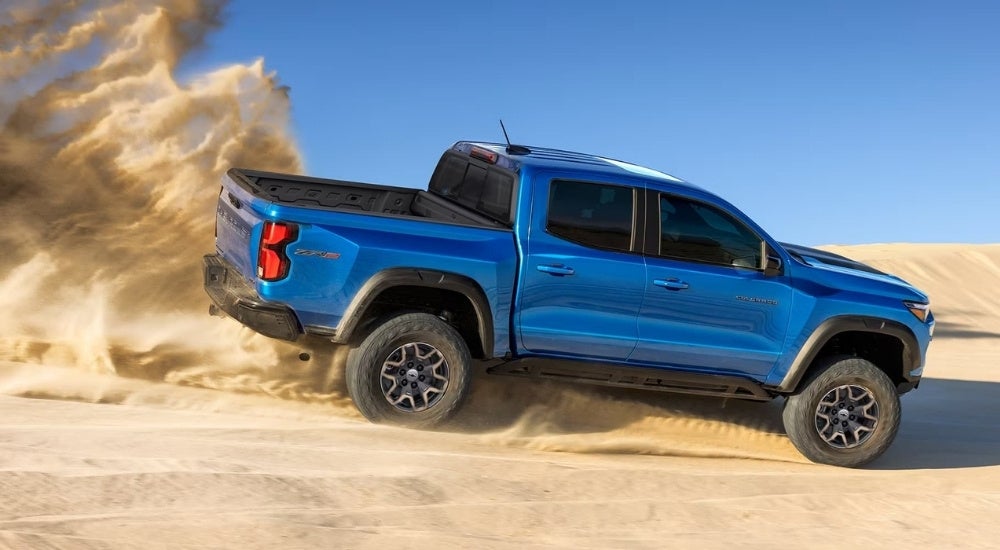 A blue 2025 Chevy Colorado ZR2 is driving off-road.