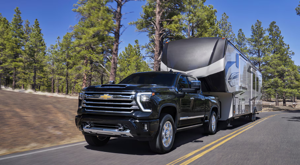 Black 2026 Chevy Silverado 2500 HD towing a camper