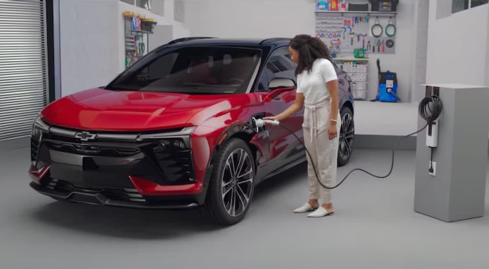 A red 2025 Chevy Blazer EV RS charging in a garage.