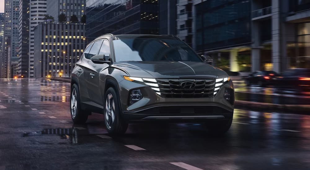 Grey 2023 Hyundai Tuscon driving on a city street.