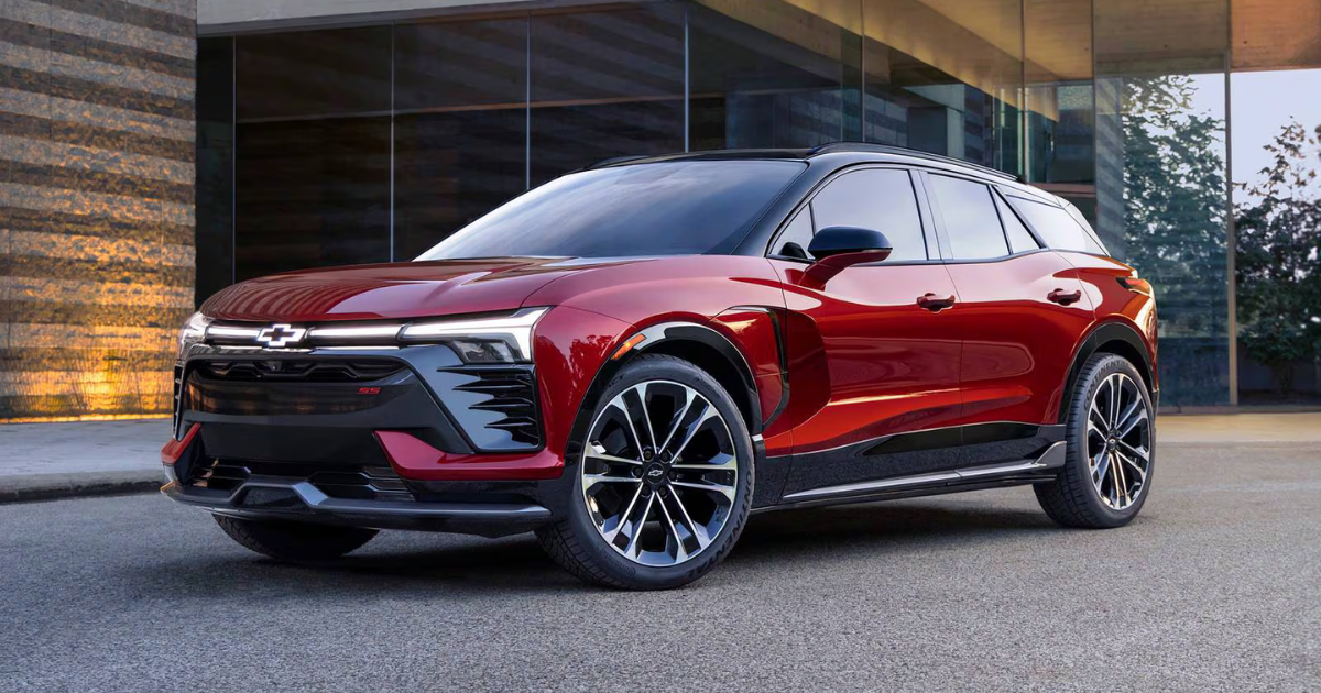 a red 2026 Chevrolet Blazer in the driveway of a modern luxury home