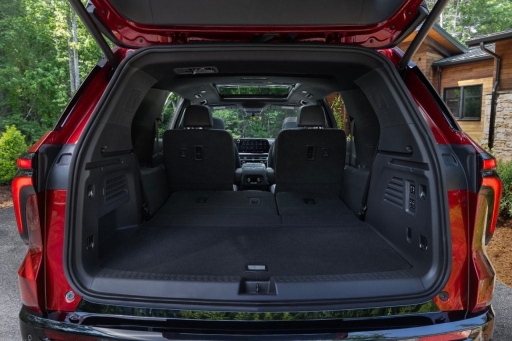 View of cargo space with third row seats folded in 2024 Chevrolet Traverse RS with a Jet Black with Red accents interior.