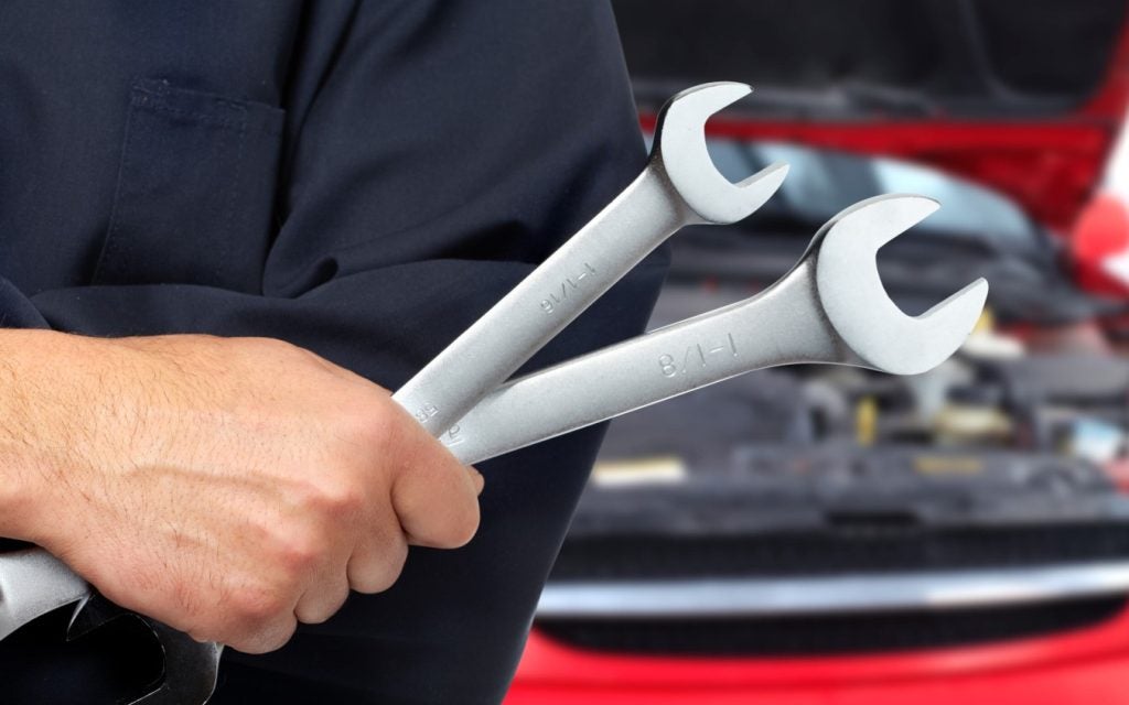 Mechanic holding wrenches