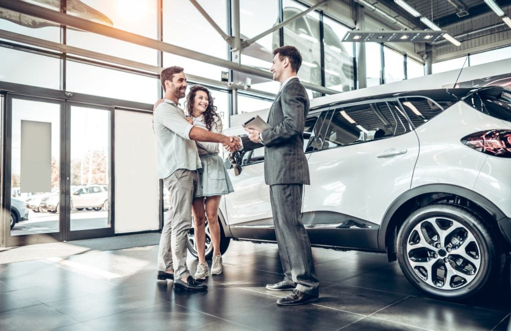 people shaking hands at a dealership