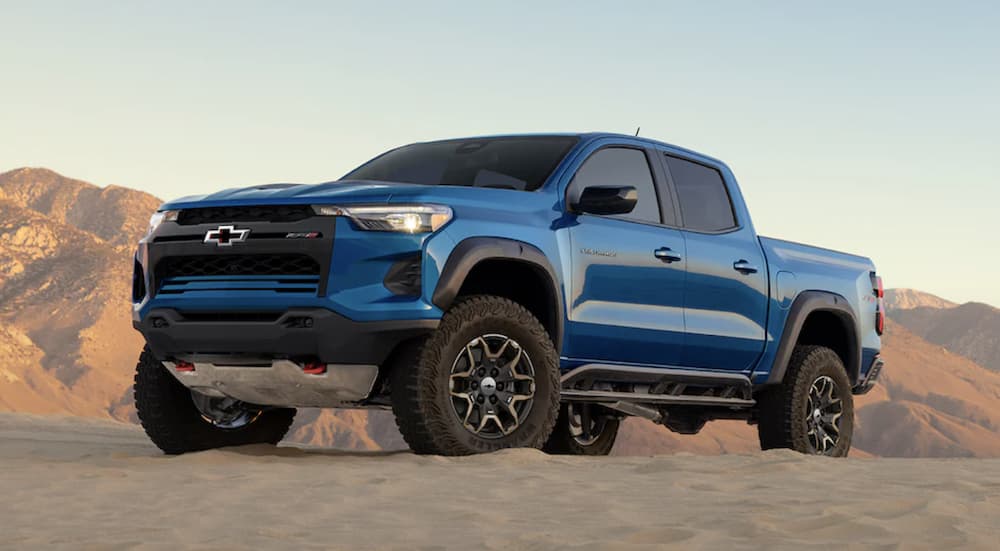 A blue 2024 Chevy Colorado ZR2 for sale off-roading in a desert.