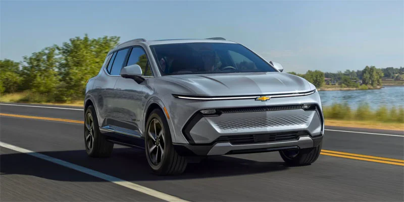 A 2025 Chevrolet Equinox EV driving down a street next to water near Wind Gap, Pennsylvania