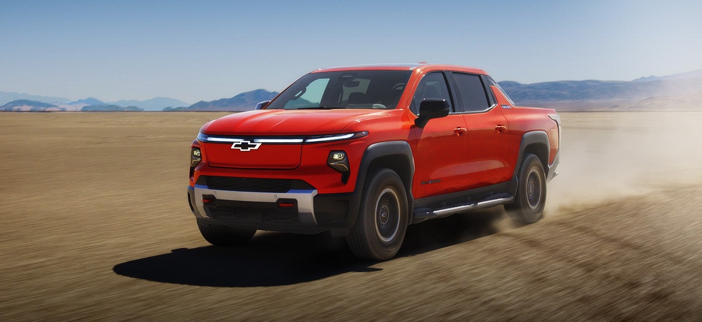 2026 Chevy Silverado EV with bold exterior design driving across a wide desert landscape