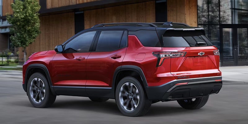 Red 2027 Chevrolet Equinox SUV outside a modern building.