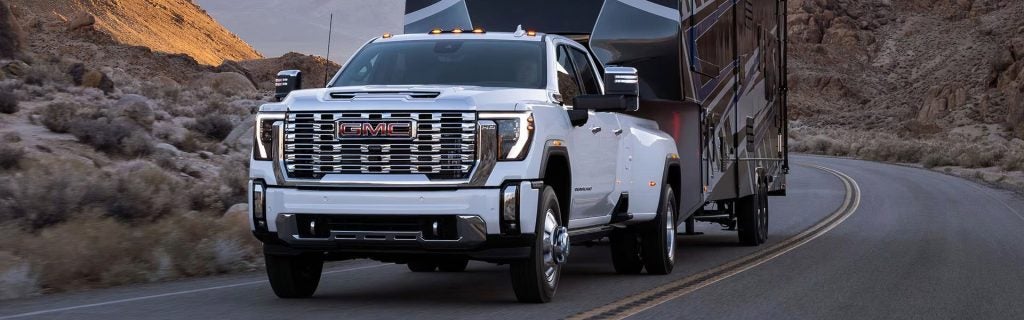 2025 GMC Sierra HD hauling a heavy load up a mountain