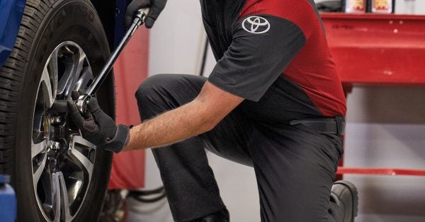 Toyota parts technician installing a tire