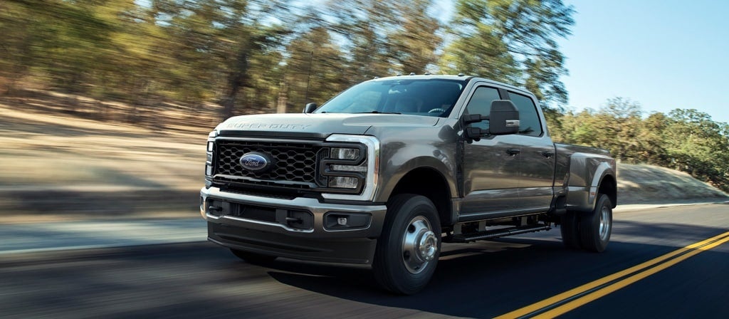 2026 Ford F-250 driving on a road with trees in the background